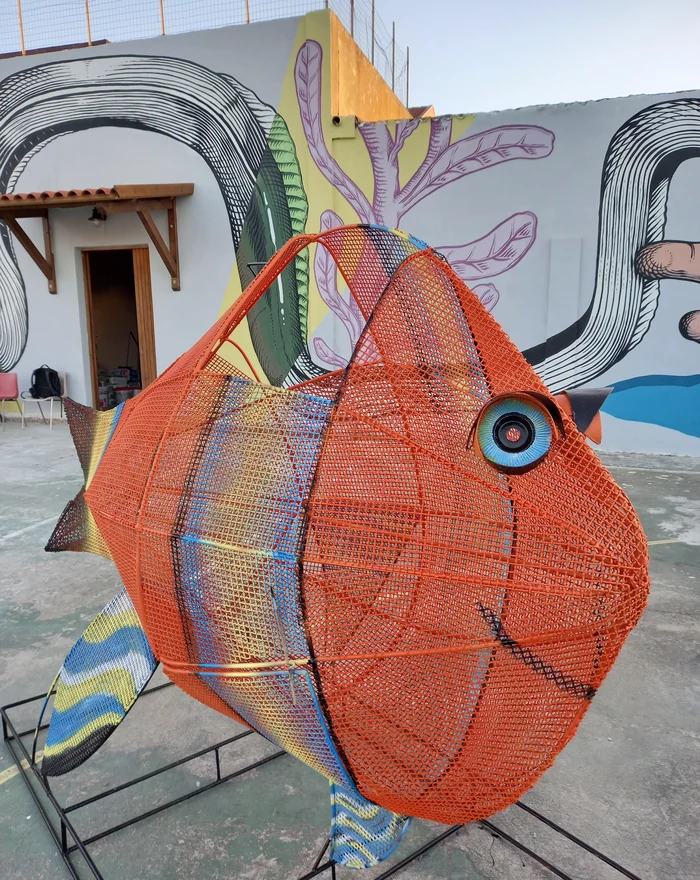 Un grande pesce arancione realizzato come installazione artistica urbana