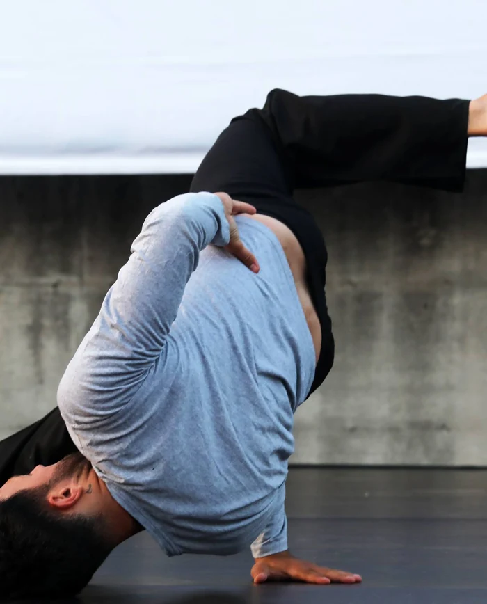 Due danzatori intrecciano i corpi in una performance a terra